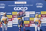Jessie Diggins, middle, celebrates with the World Cup cross-country skiing trophy on March 17 in Falun, Sweden.