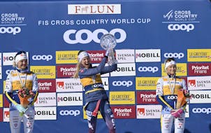 Jessie Diggins, middle, celebrates with the World Cup cross-country skiing trophy on March 17 in Falun, Sweden.