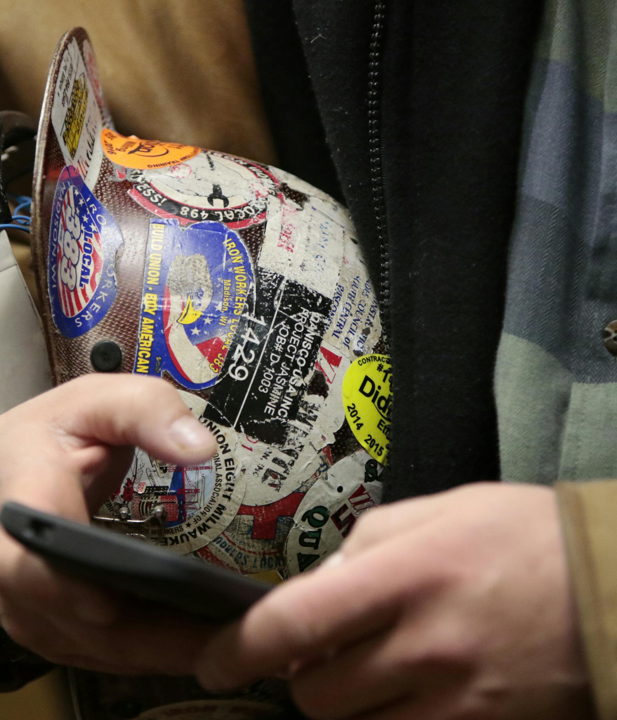 Anthony Anastasi, business agent with Iron Workers Local 383 in Madison, holds his union sticker-covered helmet during a news conference of local labor leaders at the Madison Concourse Hotel in Madison, Wis., Monday, Feb. 23, 2015. (AP Photo/Wisconsin State Journal, M.P. King)