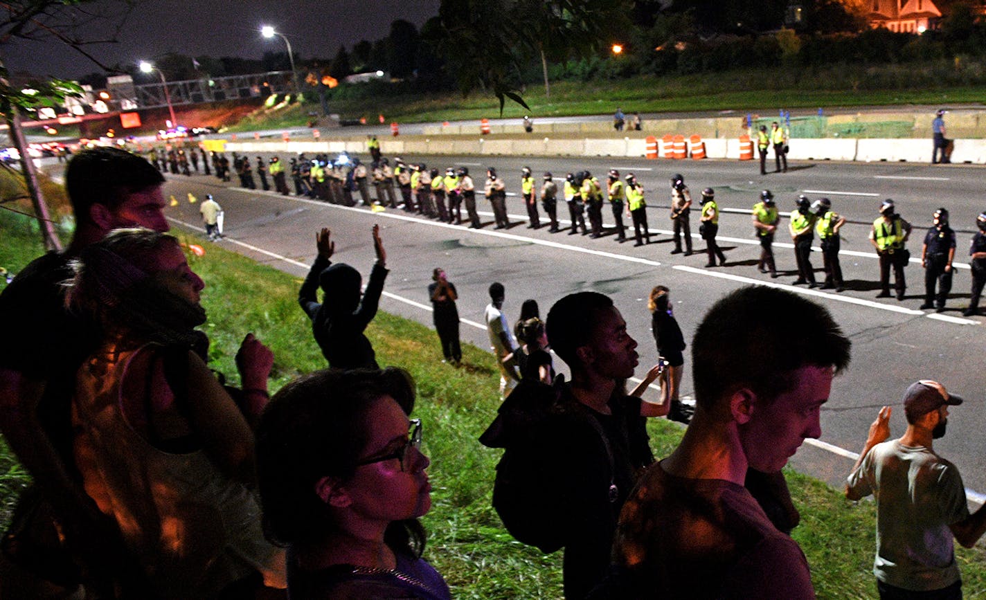 Protestors stood facing the police after police forced protestors onto the hill next to the interstate near the Dale St. exit on Saturday night. ] Isaac Hale &#xef; isaac.hale@startribune.com Protestor's Marched from the governor's mansion to I-94 and occupied the space until about midnight when police officers forced protestors off the interstate. ORG XMIT: MIN1607100152203086