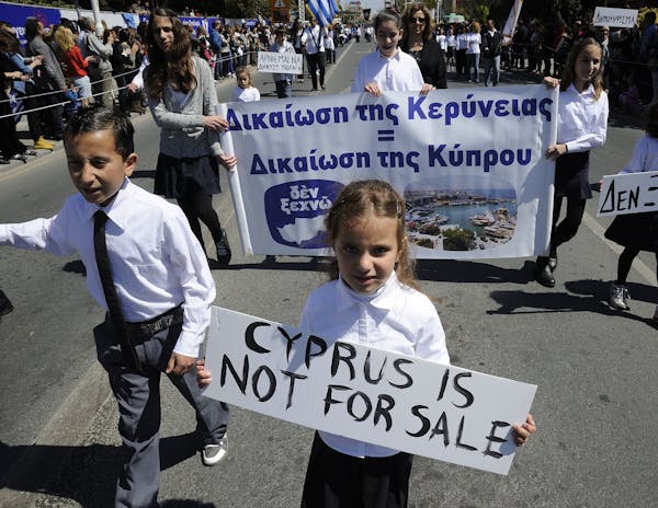 Students hold placards the ones on the right reads in Greek "we don't sell out "during a parade for Greek independence day celebrations at the souther