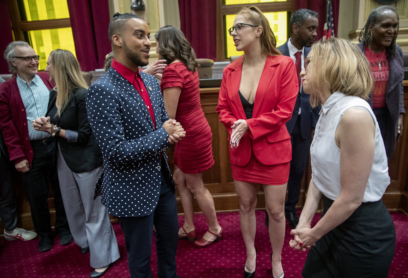 Minneapolis City Council Member Phillipe Cunningham, left, congratulated Ramona Falls, center, and Jayne Swift of the Sex Worker Outreach Project after the council passed updated rules to protect adult entertainment workers on Friday, Aug. 23.