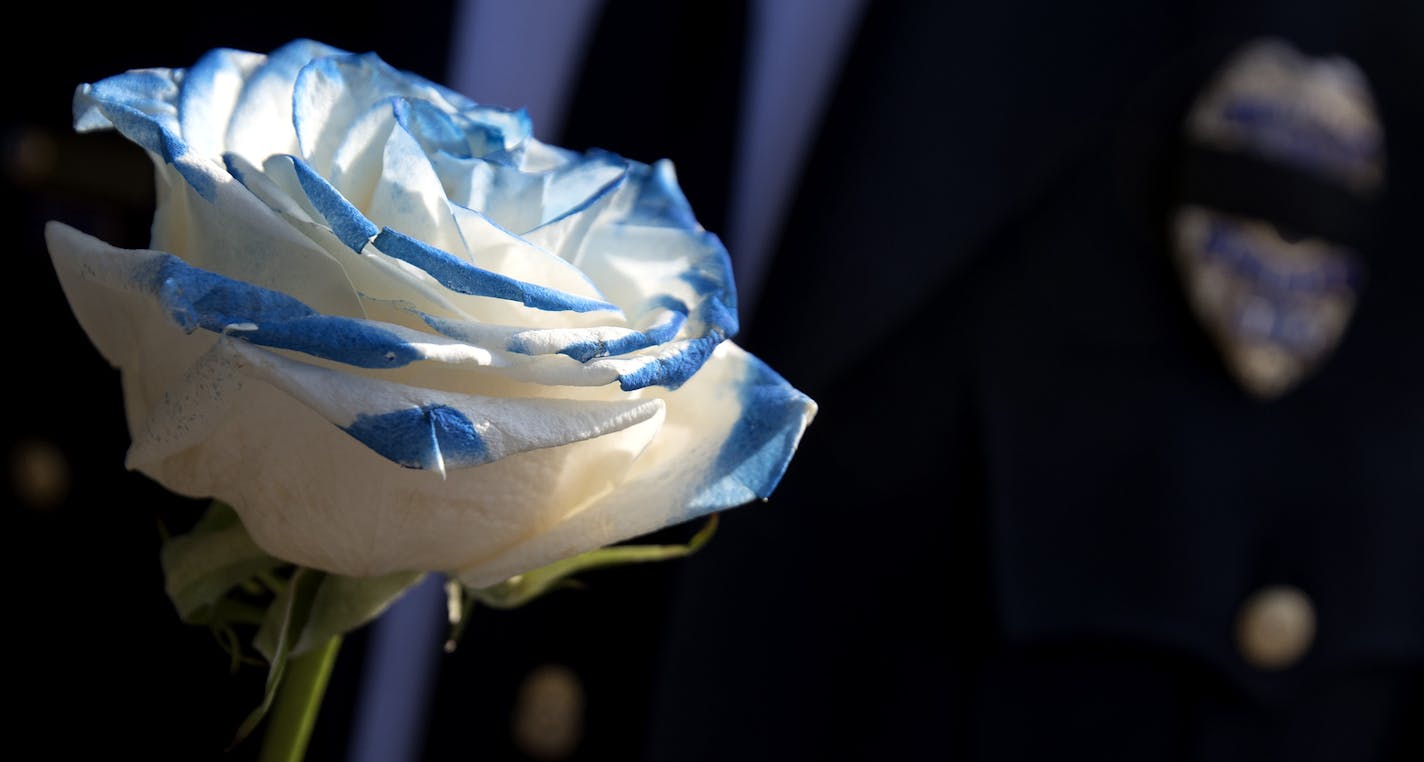 An officer held a flower at the funeral service for officer William Mathews at the Wayzata Free Church. ] CARLOS GONZALEZ &#xef; cgonzalez@startribune.com - September 14, 2017, Wayzata, MN, Wayzata Free Church, Funeral Service for Office William Mathews