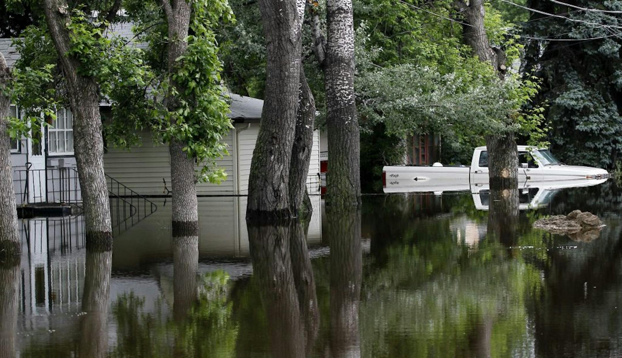 Flood waters from the Souris River surround a home and truck in the Oak Park neighborhood of Minot, N.D., on Sunday.