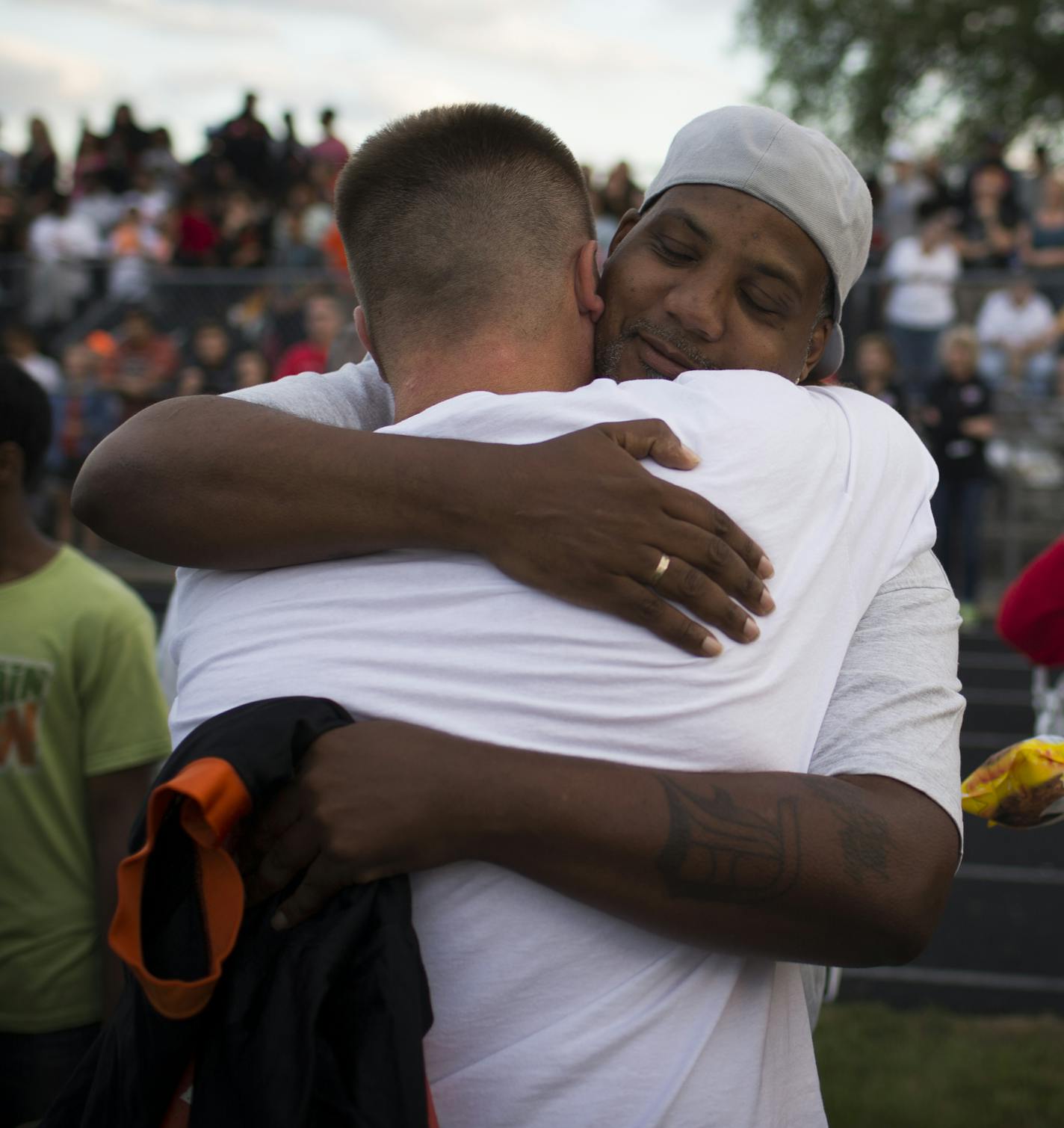 Sha-kym Adam's father Sharrod Rowe hugged South head coach Lenny Sedlock as his mother Kimberly Adams, right, cried while holding his jersey during a memorial time for Sha-kym at the first football game of the season at South High School in Minneapolis, Minn. August 27, 2014. Adams was a football player and died earlier this month in a drowning accident. ] RENEE JONES SCHNEIDER &#x2022; reneejones@startribune.com