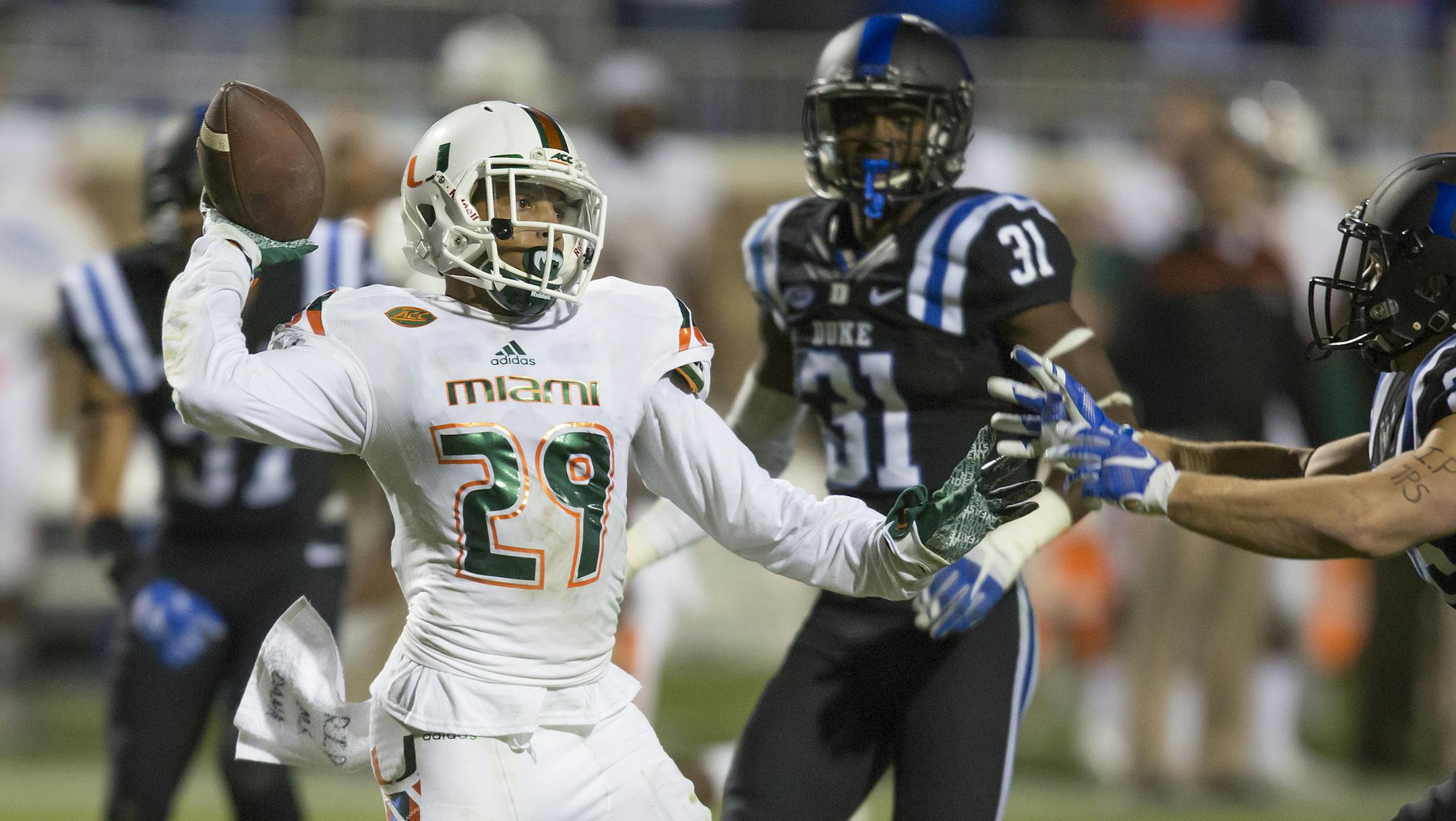Miami's Corn Elder throws a lateral during a kickoff return which featured multiple laterals before Elder subsequently received the final lateral and scored to beat Duke 30-27 in an NCAA college football game, in Durham, N.C., Saturday, Oct. 31, 2015. (AP Photo/Rob Brown)