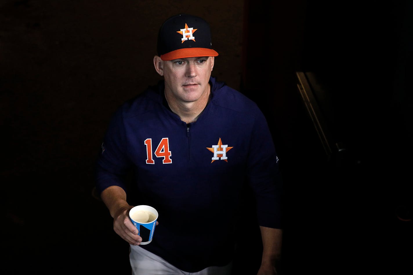 Major League Baseball announced Monday that it would penalize the Houston Astros for illegally stealing signs during their World Series championship season in 2017. In this file photo, Houston Astros manager A.J. Hinch walks into the dugout from the locker room before a game in 2019.