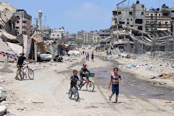 Palestinian children ride their bicycles along a street devastated by Israeli bombardment in Gaza City on May 3, amid the ongoing conflict between Isr