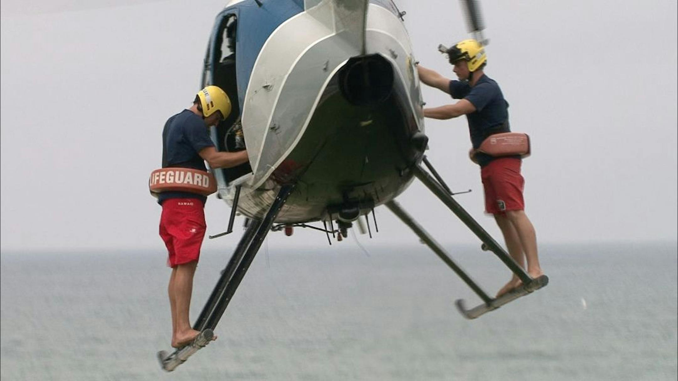 In this undated image released by The Weather Channel, two lifeguards prepare to make a rescue in a scene from ""Lifeguard!," about beach rescuers in southern California. The series airs Thursdays at 9 p.m. on The Weather Channel. The Weather Channel is in the midst of a transformation with original programming about Arctic pilots, steel workers, wind turbine and power line repairers and Coast Guard rescuers in both icy and tropical climates.