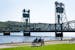 People lounge on a bench and look out at the St. Croix River and historic Stillwater Lift Bridge Thursday, Sep. 14, 2023, in Lowell Park in Stillwater