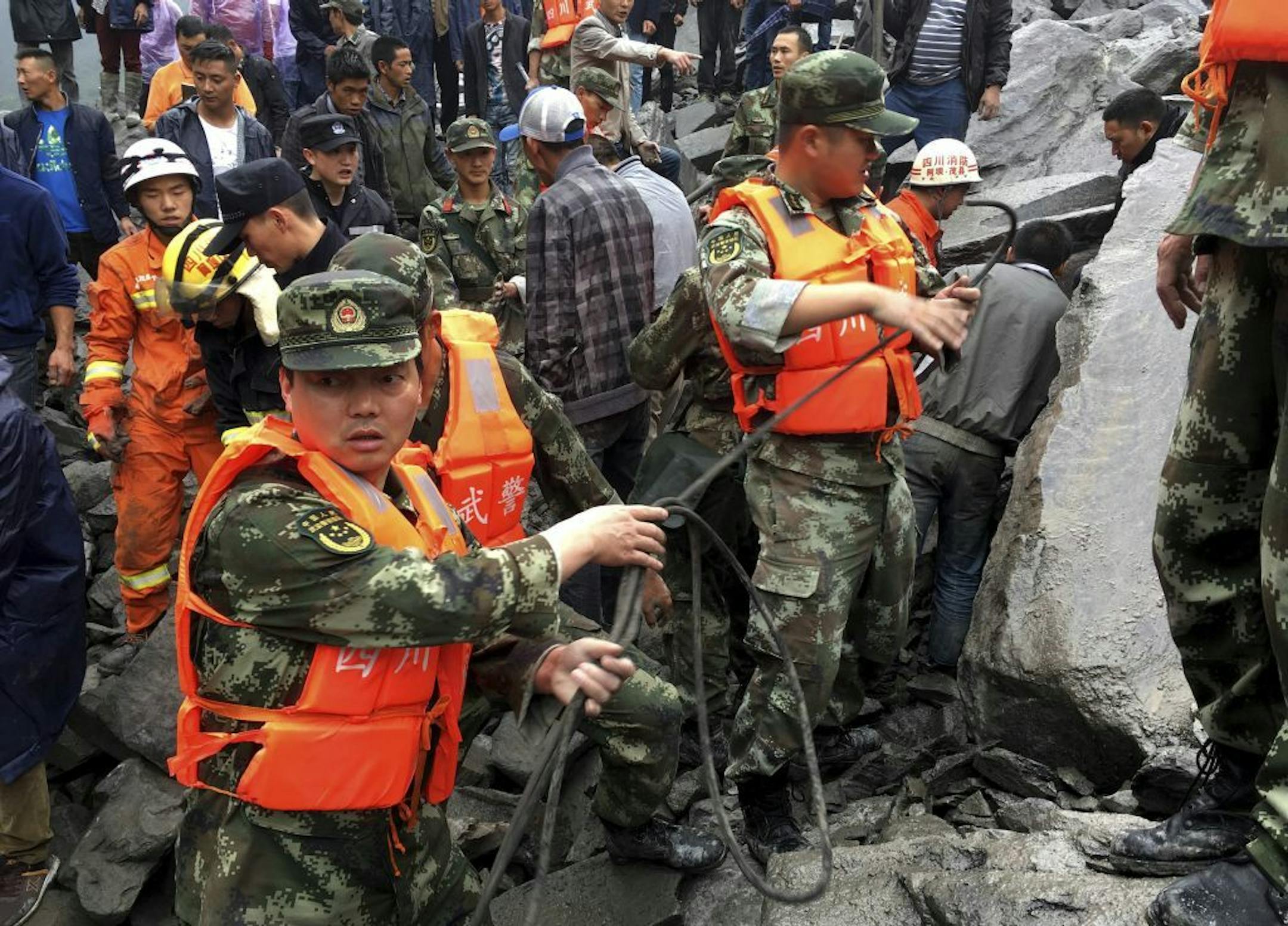 Emergency personnel work at the site of a massive landslide in Xinmo village in Maoxian County in southwestern China's Sichuan Province, Saturday, June 24, 2017. Dozens of people are feared buried by a landslide that unleashed huge rocks and a mass of earth that crashed into their homes in southwestern China early Saturday, a county government said.