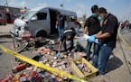 Pakistani investigators examine the site of a suicide attack in Karachi, Pakistan, Friday, April 19, 2024. A suicide bomber detonated his explosive-la