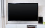Large flat screen TV mounted to the wall in modern interior living room. istock photo