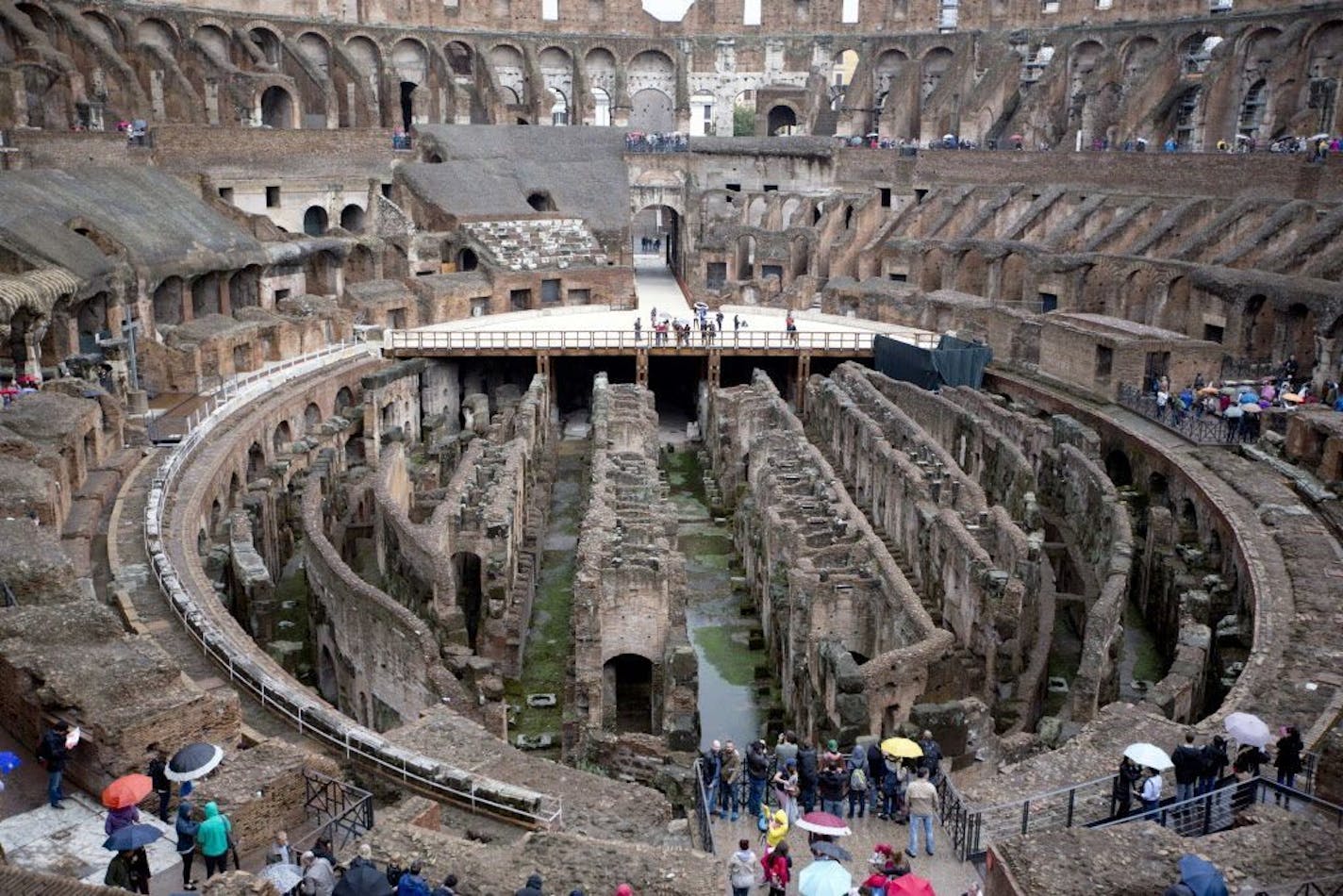 Tourists gather at Rome's Colosseum, Friday Nov. 7, 2014. An archaeologist's proposal to return the Colosseum's storied arena to its original state has sparked a lively debate.