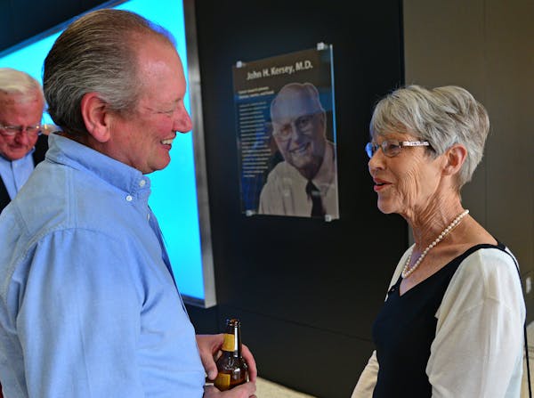 Dr. John Kersey's patient David Stahl talked with Anne Kersey whose husband is seen in the background with a glass plaque. He was a boy when he was sa