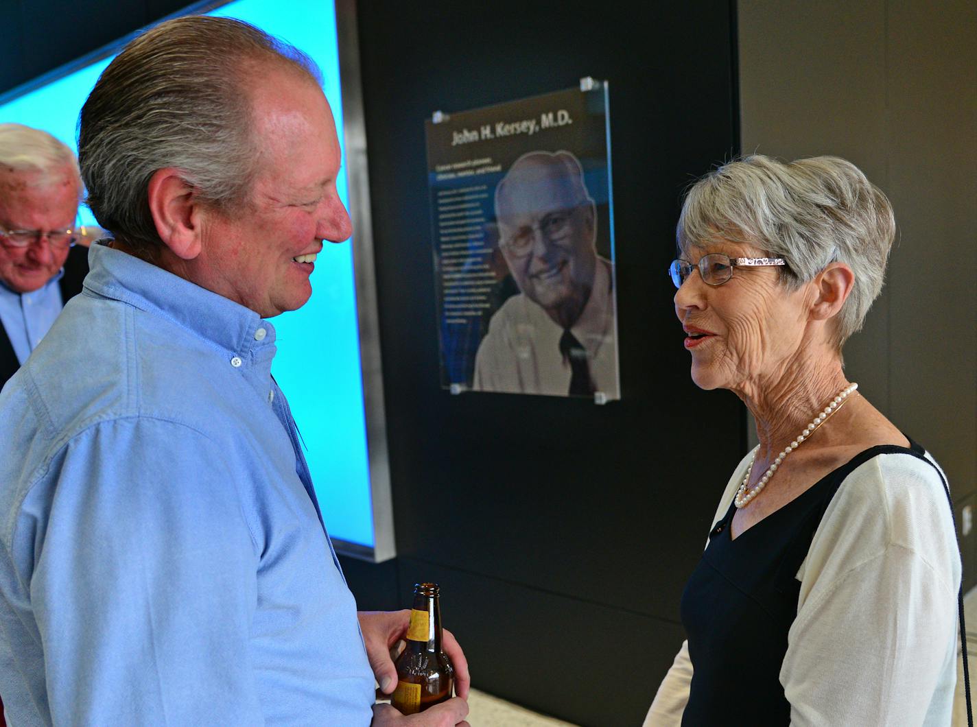 Dr. John Kersey's patient David Stahl talked with Anne Kersey whose husband is seen in the background with a glass plaque. He was a boy when he was saved from malignant lymphoma in 1975, with the first bone-marrow transplant succcess. ] The dedication ceremony honoring Dr. John Kersey, a U of M cancer research pioneer was held today at the new Cancer and Cardiovascular Research Building. Richard.Sennott@startribune.com Richard Sennott/Star Tribune Minneapolis Minn. Monday 5/13/2014) ** (cq) ORG