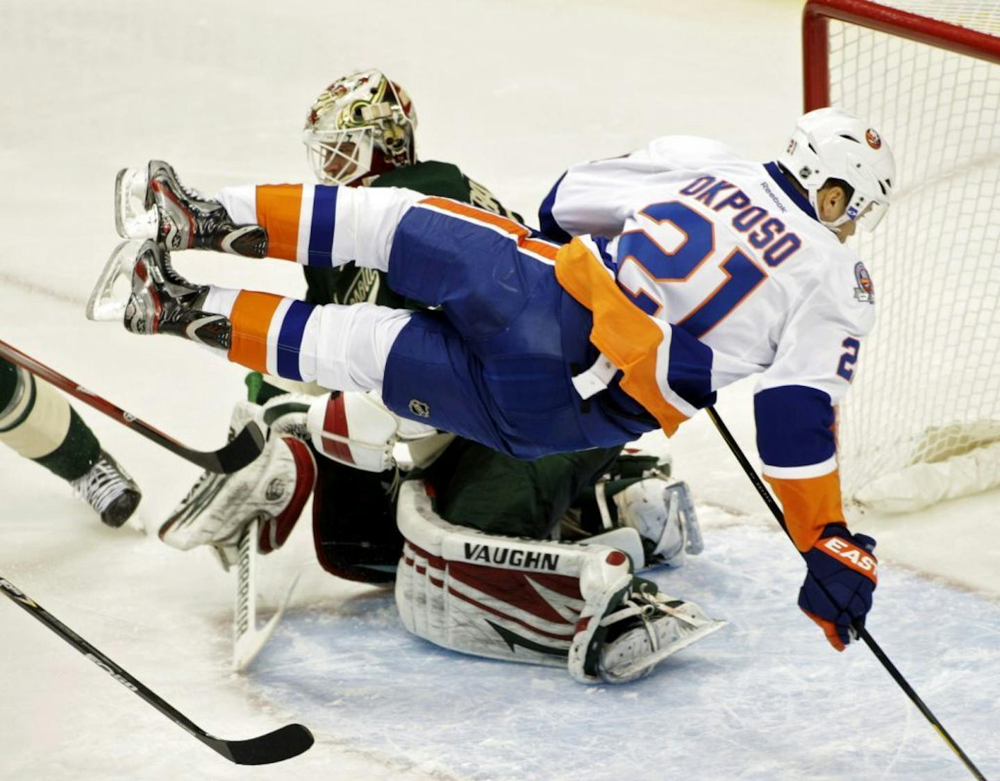 New York Islanders right wing Kyle Okposo (21) goes airborne as he skates in on Minnesota Wild goalie Niklas Backstrom (32), of Finland, during the third period in an NHL hockey game, Saturday, Dec. 17, 2011, in St. Paul, Minn. The Islanders won 2-1 in a shootout.