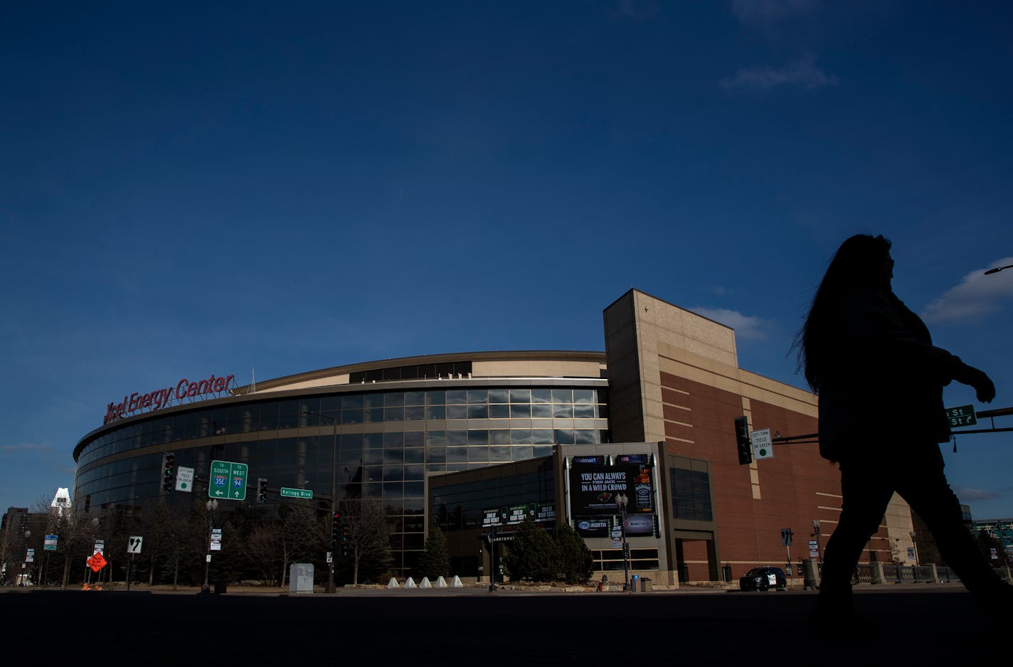 Pedestrians crossed the street in front of the Xcel Energy Center on Sunday. The Wild were scheduled to have a home game before the NHL paused the season. ] CARLOS GONZALEZ • cgonzalez@startribune.com – St. Paul, MN – March 15, 2020, There will be no fans at Xcel Energy Center on Sunday night, no people crowding the streets and the bars. The Wild game is canceled,