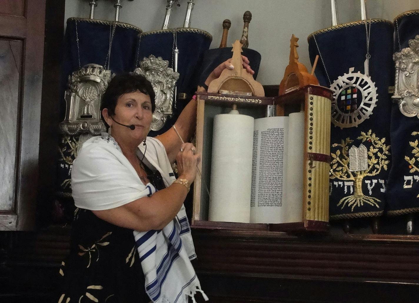 Cantor Diane Becker Krasnick with the Moroccan Torah in the Ark of the Hebrew Congregation of St. Thomas in the U.S. Virgin Islands. The third Torah from the left has an inventory number put there by Nazi looters of a Czech synagogue. (Sharon Eberson/Pittsburgh Post-Gazette/MCT) ORG XMIT: 1147923