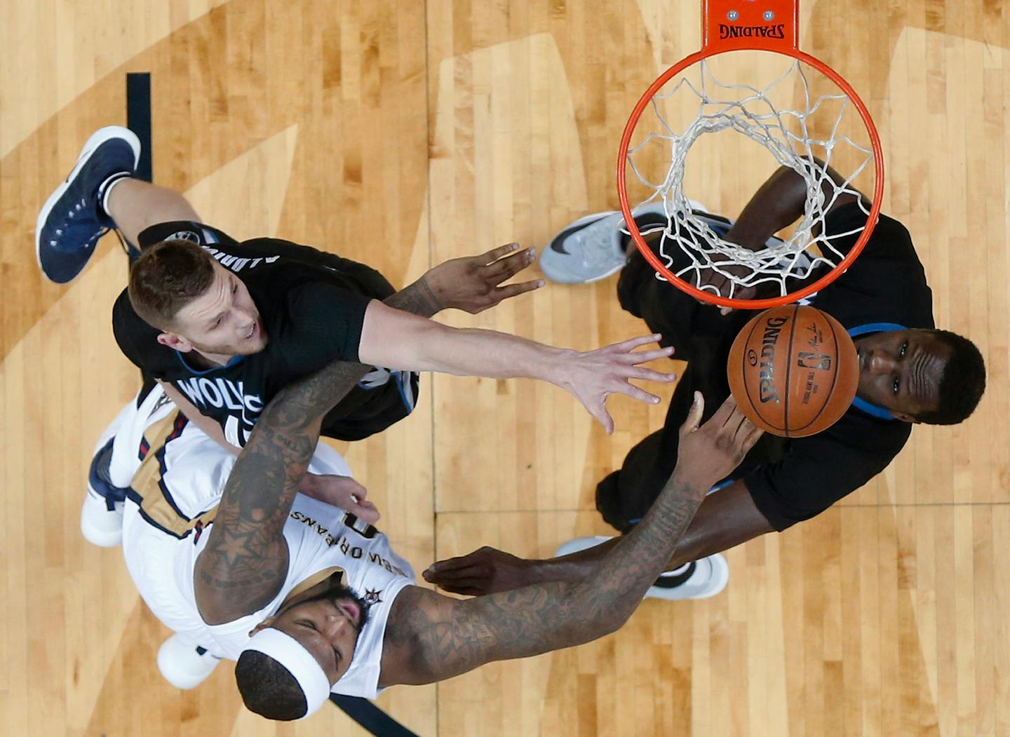 Pelicans forward DeMarcus Cousins, bottom left, shot against Timberwolves center Cole Aldrich, top left, and forward Gorgui Dieng in the first half in New Orleans on Sunday.