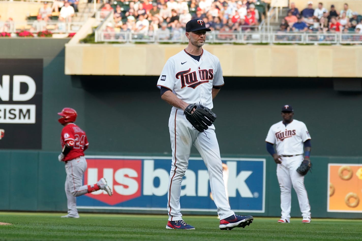 Minnesota Twins pitcher J.A. Happ, center, waits as Los Angeles Angels' Kurt Suzuki, left, rounds the bases on a two-run home run during the first inning of a baseball game, Friday, July 23, 2021, in Minneapolis. (AP Photo/Jim Mone)