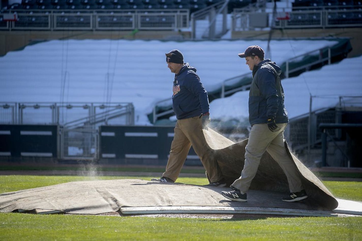 Andrew Warcken, left, and Jordan Gretzlock, with the Minnesota Twins grounds crew, removed the tarp from the pitchers mound at Target Field, Friday, March 6, 2020 in Minneapolis, MN.