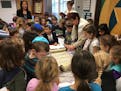 Dori Wolgel, the tífilah educator at Solomon Schechter Day School of Metropolitan Chicago, reads from a Torah that survived the Holocaust as second g