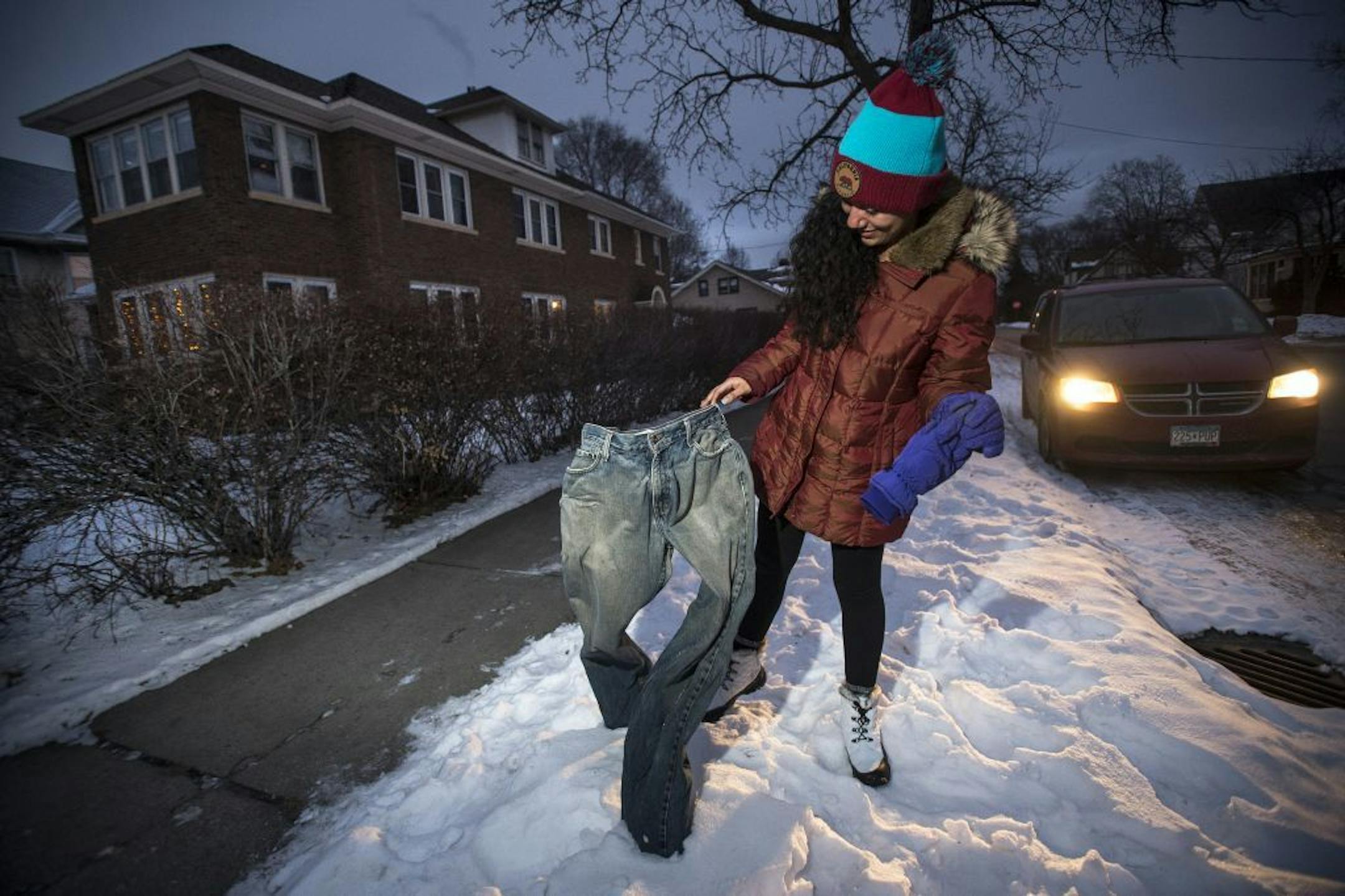 Melissa Valladares, visiting from El Salvador for an internship, investigated a pair of frozen blue jeans on display at the intersection of 16th Avenue Northeast and 2nd Street Northeast on Tuesday, Jan. 19, 2016 in Minneapolis, Minn. The jeans were put out by Randall Johnson, of Minneapolis, a former student of MCAD.