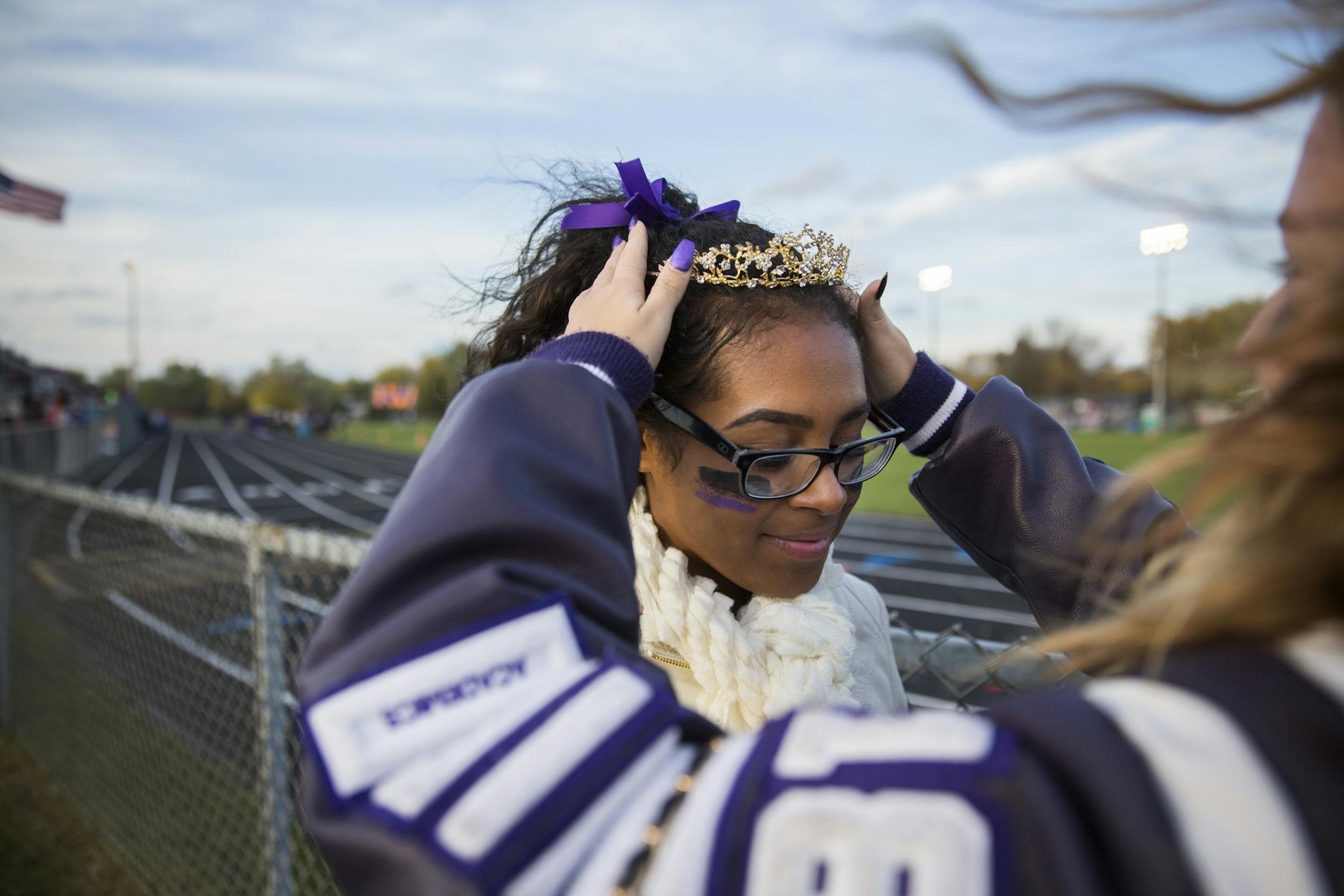 Homecoming queen Gena Burns gets a crown adjustment from a friend before halftime.