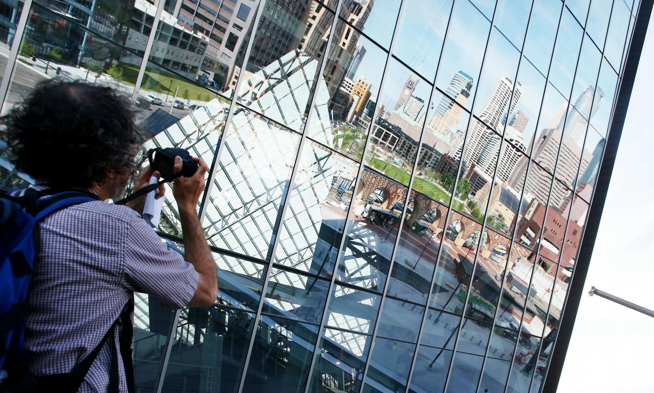 Downtown Minneapolis is reflected on the exterior glass as the see-through roof is visible outside the Mystic Lake Club during a media tour Tuesday, July 19, 2016, at U.S. Bank Stadium in Minneapolis, MN.