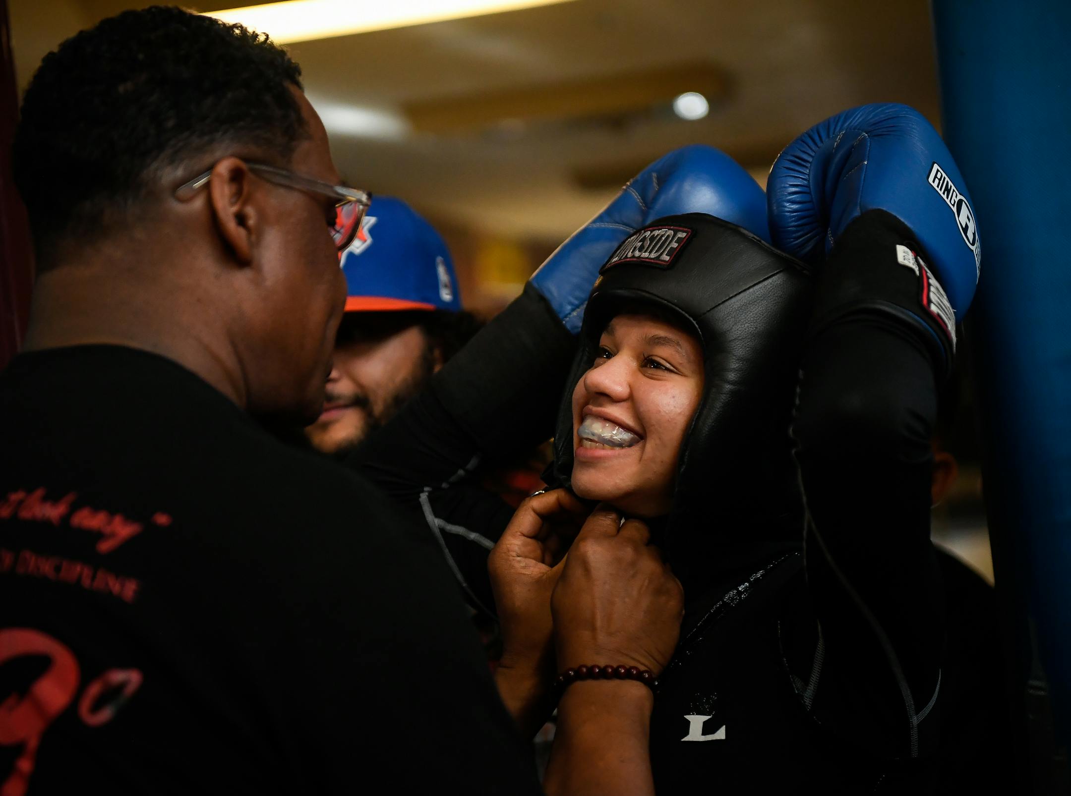 Circle of Discipline head coach Sankara Frazier put on Amaiya Zafar's boxing headgear just before her fight Saturday night. ] AARON LAVINSKY &#xef; aaron.lavinsky@startribune.com Feature story on Amaiya Zafar, female boxer who won the right to wear a hijab in the ring. She fought Saturday, April 29, 2017 at Richard Green Central Elementary School in Minneapolis, Minn.