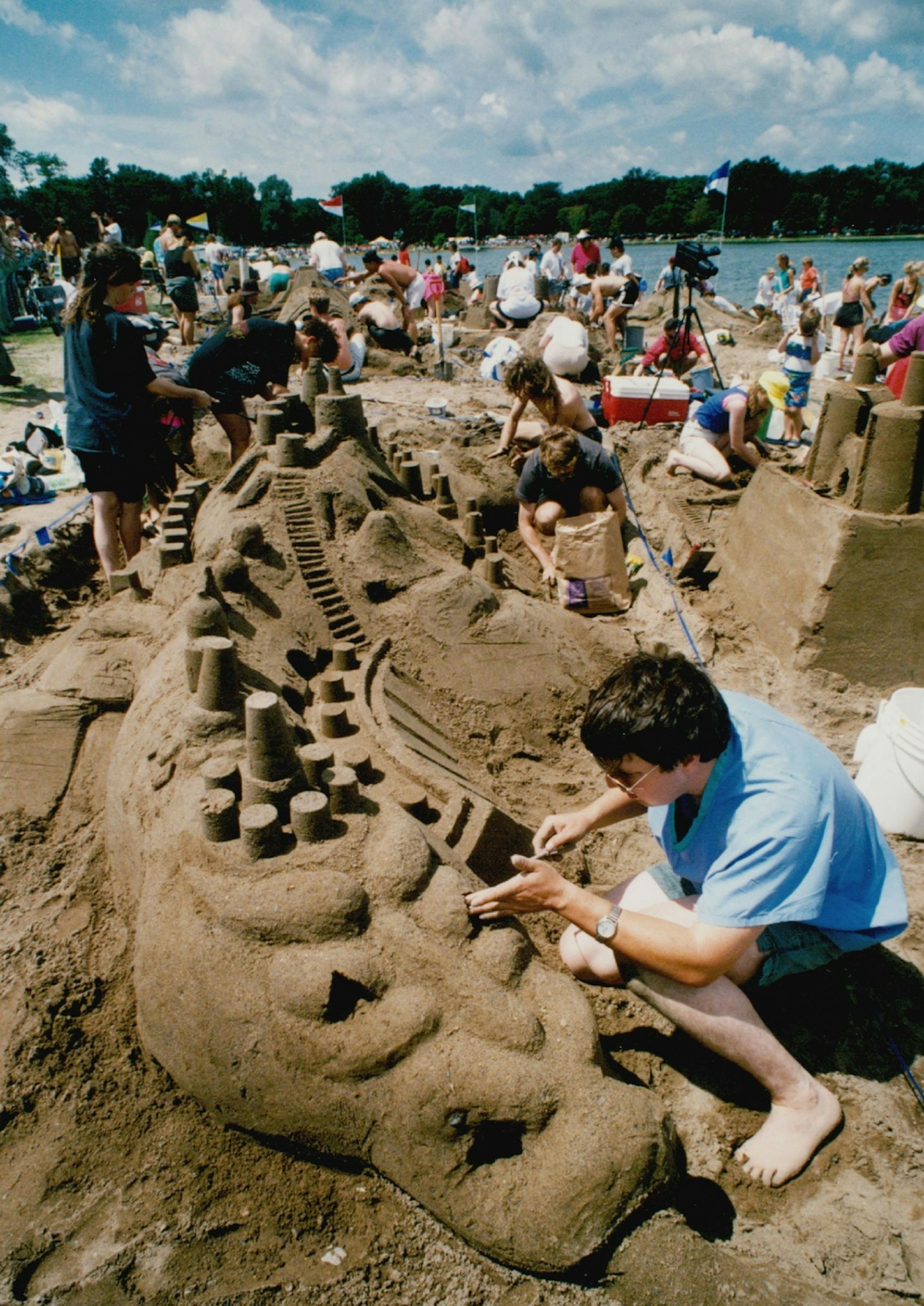 July 26, 1992: Sand Castle / Sculpture Competiton at Lake Calhoun. Gerry Prouix, a member of the sand Salyers team, puts the finishing touches on their dragon castle.
