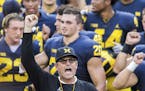 FILE - In this Aug. 26, 2018, file photo, Michigan head coach Jim Harbaugh leads his players and fans in singing "Hail to the Victors" after a practic