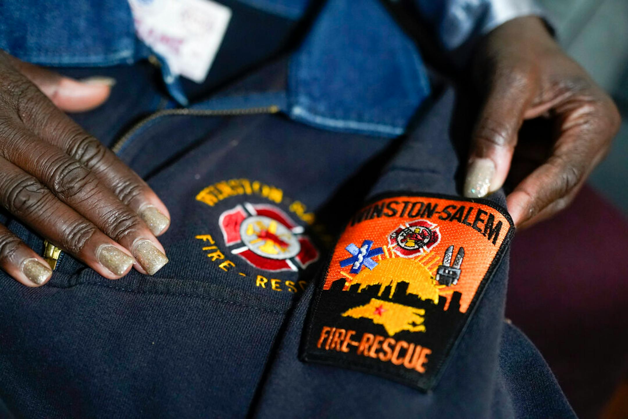 Timika Ingram holds a jacket she had when she was a firefighter on Thursday, Nov. 19, 2020, in Charlotte, N.C.