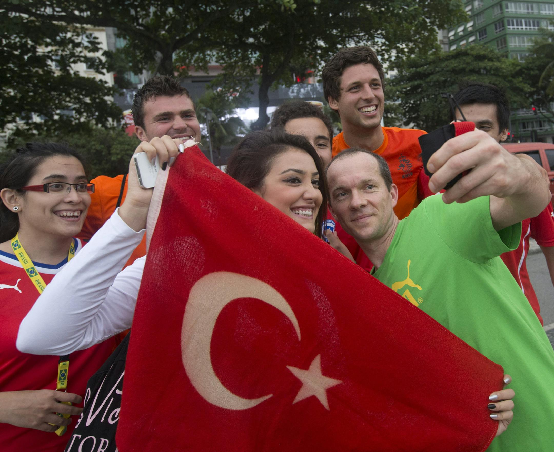 Fans of Turkey, Chile, and Neatherlands pose for a selfie at Copacabana beach in Rio de Janeiro, Brazil, Tuesday, June 10, 2014. Soccer fans around the world are gearing up to watch the World Cup that kicks off Thursday in Brazil. (AP Photo/Silvia Izquierdo)