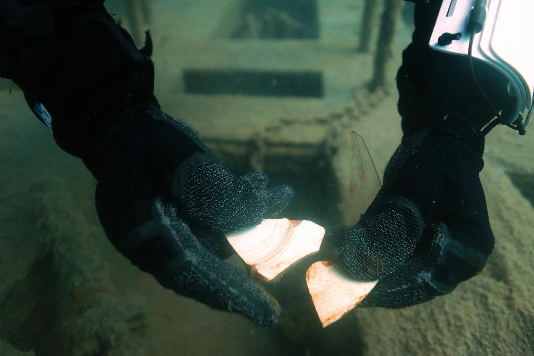 Jack Decker, a diver with the Great Lakes Shipwreck Preservation Society from Clear Lake, Iowa, pulled out broken pieces of a plate from the Hesper.