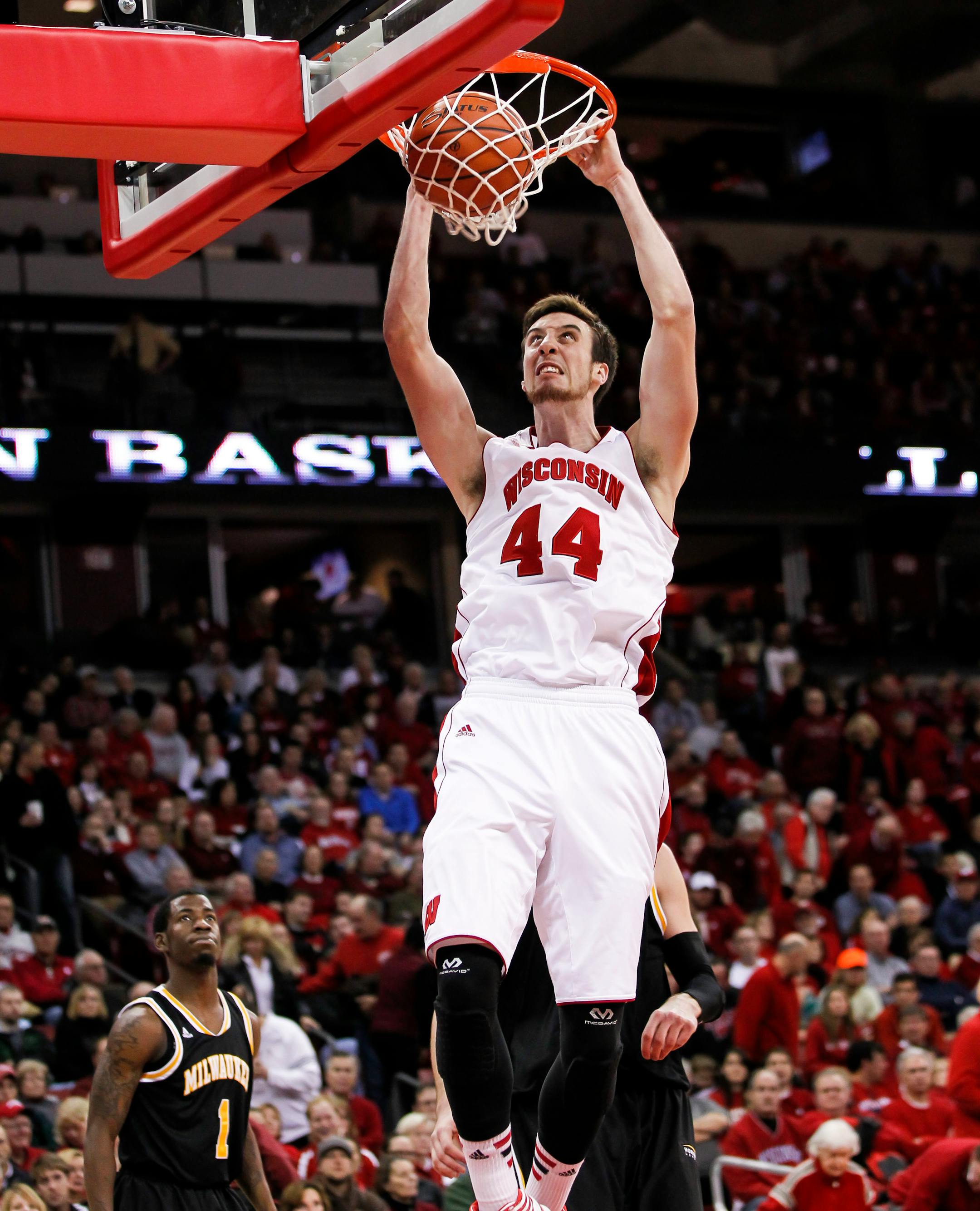 Wisconsin's Frank Kaminsky dunks past Milwaukee's Jordan Aaron (1) during the second half of an NCAA college basketball game on Wednesday, Dec. 11, 2013, in Madison, Wis. Wisconsin won 78-52. (AP Photo/Andy Manis)