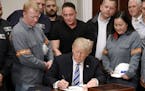 U.S. President Donald Trump signs the Section 232 Proclamations on Steel and Aluminum Imports during a ceremony at the White House Thursday, March 8, 