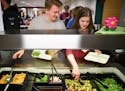 On their plates: Isaiah Damitz and Ellie Boisen went through the lunch line at Owatonna High School, taking the requisite mix of healthful options. Re