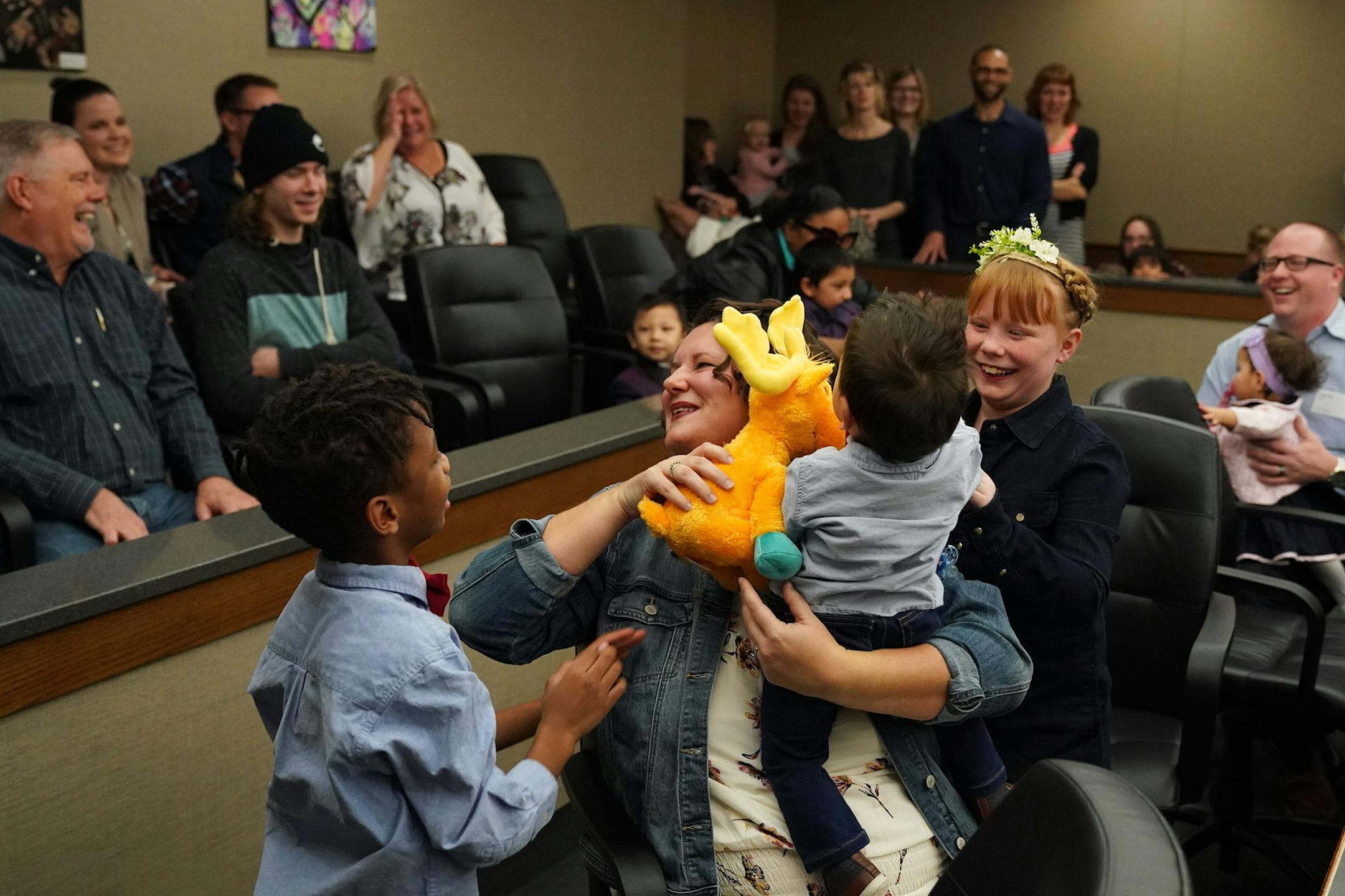 Jenny Hall smiled after just adopting her son Titus, 15-months, in the courtroom while her husband Cullen, right, held Titus' twin sister, and their adopted daughter, Charlotte, as her other adopted son Nehemiah, 7, brought over a stuffed animal and Eleanor, 8, sat between during National Adoption Day at the Juvenile Justice Center. ] ANTHONY SOUFFLE • anthony.souffle@startribune.com On National Adoption Day, 14 families adopted 22 children Saturday, Nov. 23, 2019 at the Juvenile Justice