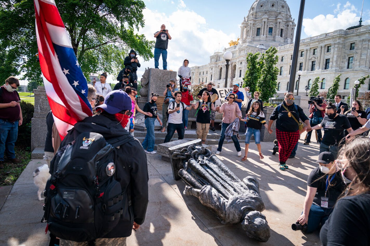 People danced in a circle around the Christopher Columbus statue after it was toppled Wednesday on the Minnesota State Capitol grounds in St. Paul.