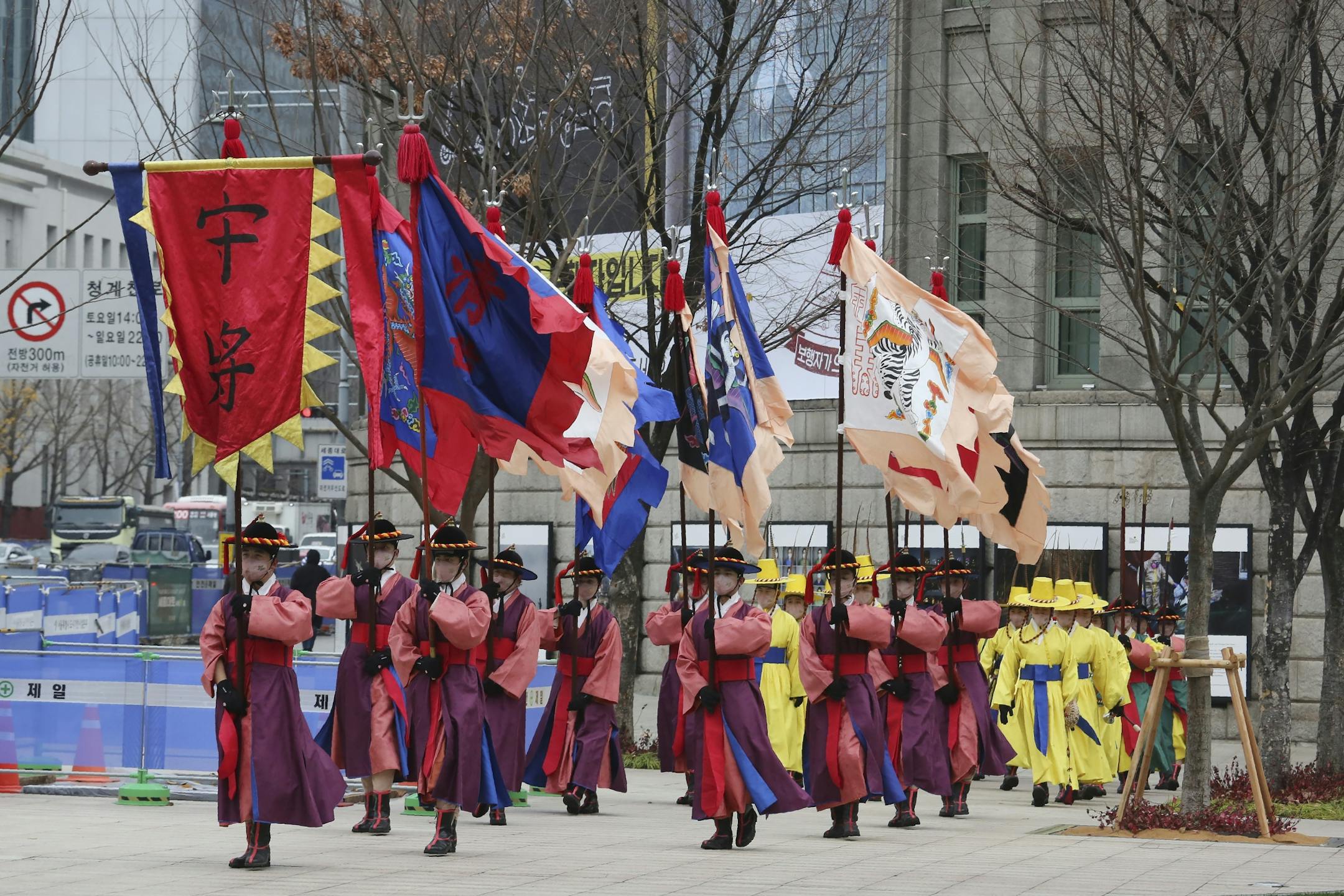 Performers wearing traditional guard uniforms and protective face masks as a precaution against the coronavirus march on a street in Seoul, South Korea, Friday, Nov. 20, 2020. South Korea's prime minister has urged the public to avoid social gatherings and stay at home as much as possible as the country registered more than 300 new virus cases for a third consecutive day.