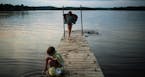 Haley Cosert, 6, of Brainerd, dipped her toes into the water as her sister, Emelia, 9, dried off after swimming in Rice Lake, a small lake formed on t