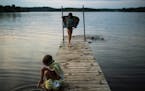 Haley Cosert, 6, of Brainerd, dipped her toes into the water as her sister, Emelia, 9, dried off after swimming in Rice Lake, a small lake formed on t