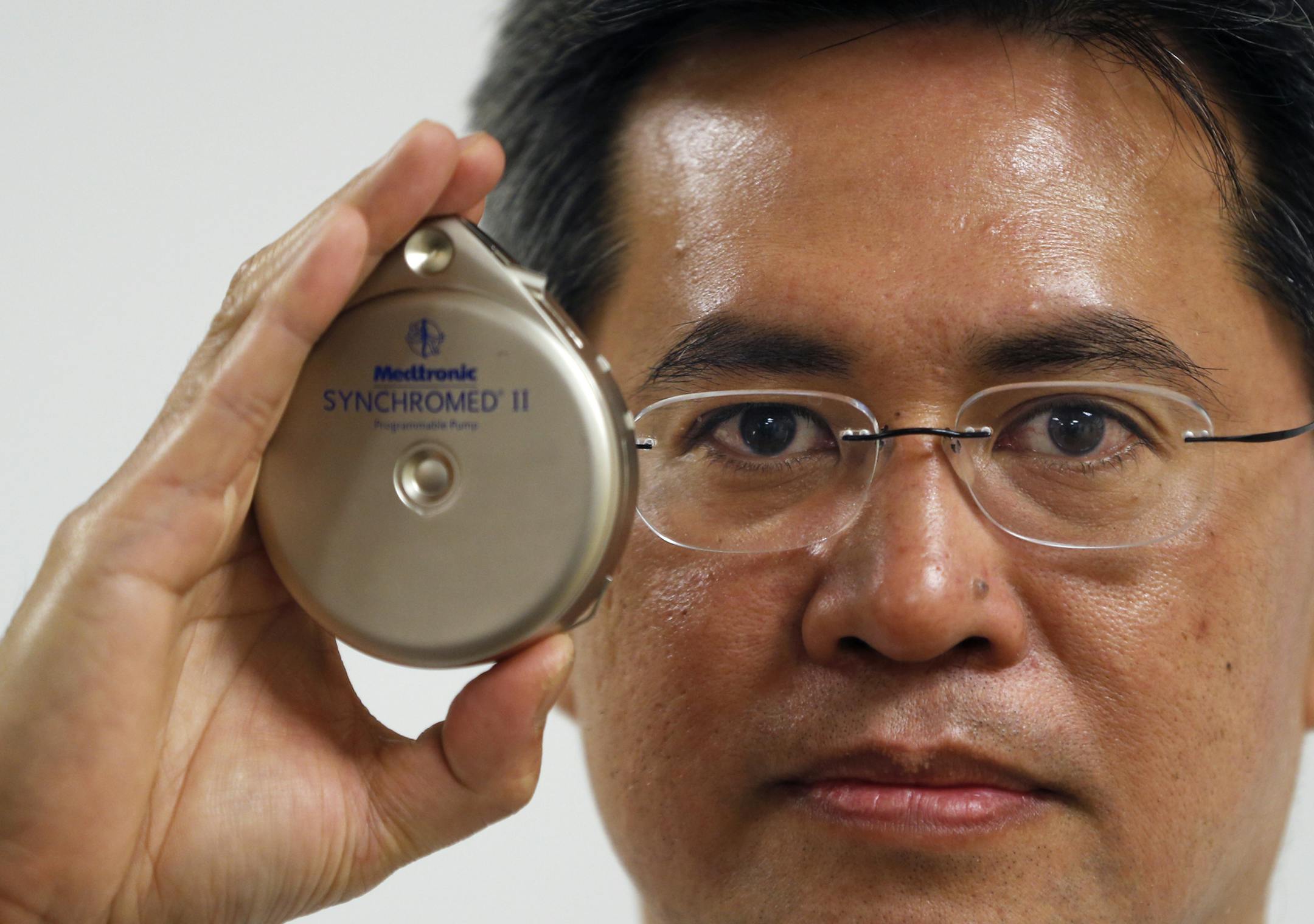 In Jackson, Florida, Dr. Phillipp Aldana, Matthew Taylor's pediatric neurosurgeon at the University of Florida-Jacksonville shows off a Medtronic pump that can deliver deliver micro doses of drugs to control chronic conditions such as cerebral palsy. ] tsong-taataarii@startribune.com ORG XMIT: MIN1307091350473229