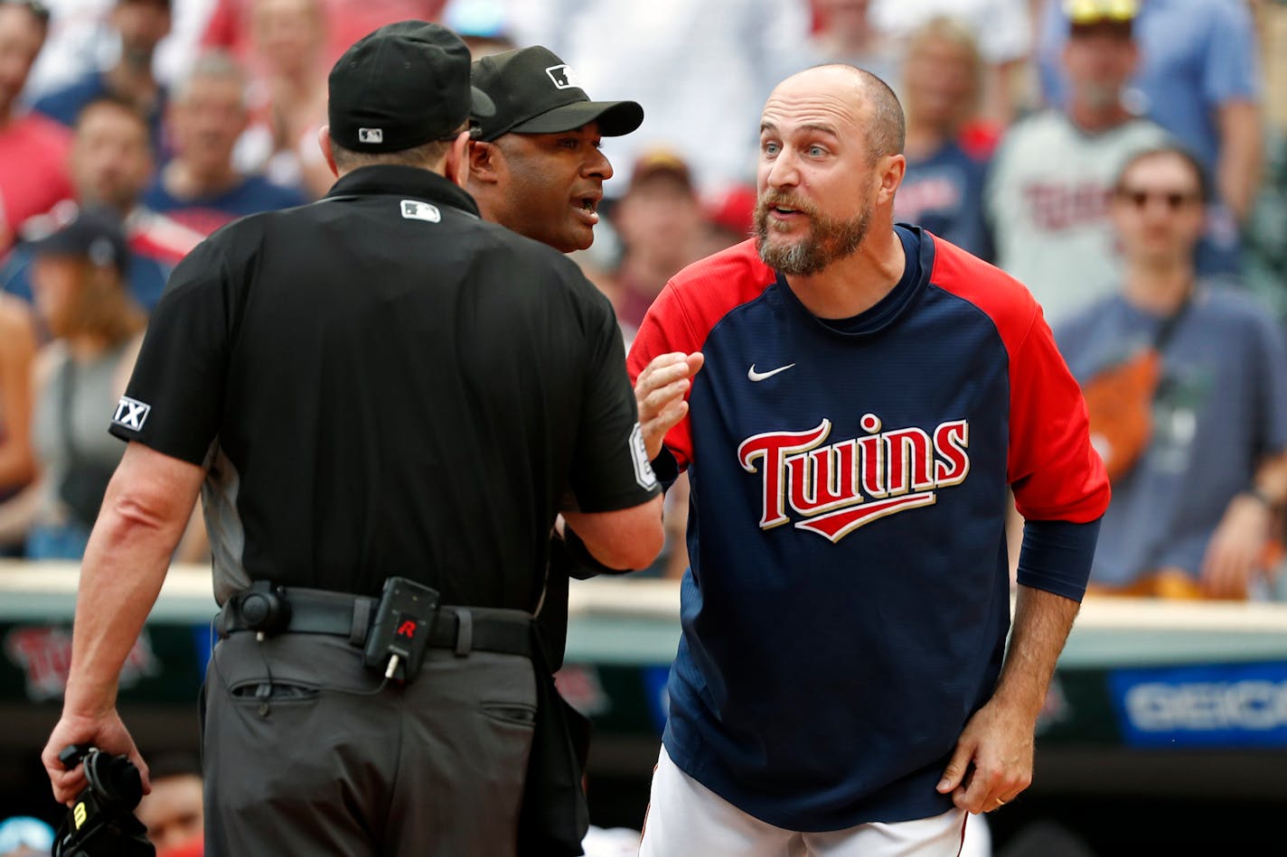 Minnesota Twins manager Rocco Baldelli, right, argues with umpires Marty Foster, left, and Alan Porter after a review reversed a call that originally had Toronto Blue Jays' Whit Merrifield out at home in the 10th inning of a baseball game Sunday, Aug. 7, 2022, in Minneapolis. The Blue Jays won 3-2 in 10 innings. (AP Photo/Bruce Kluckhohn)