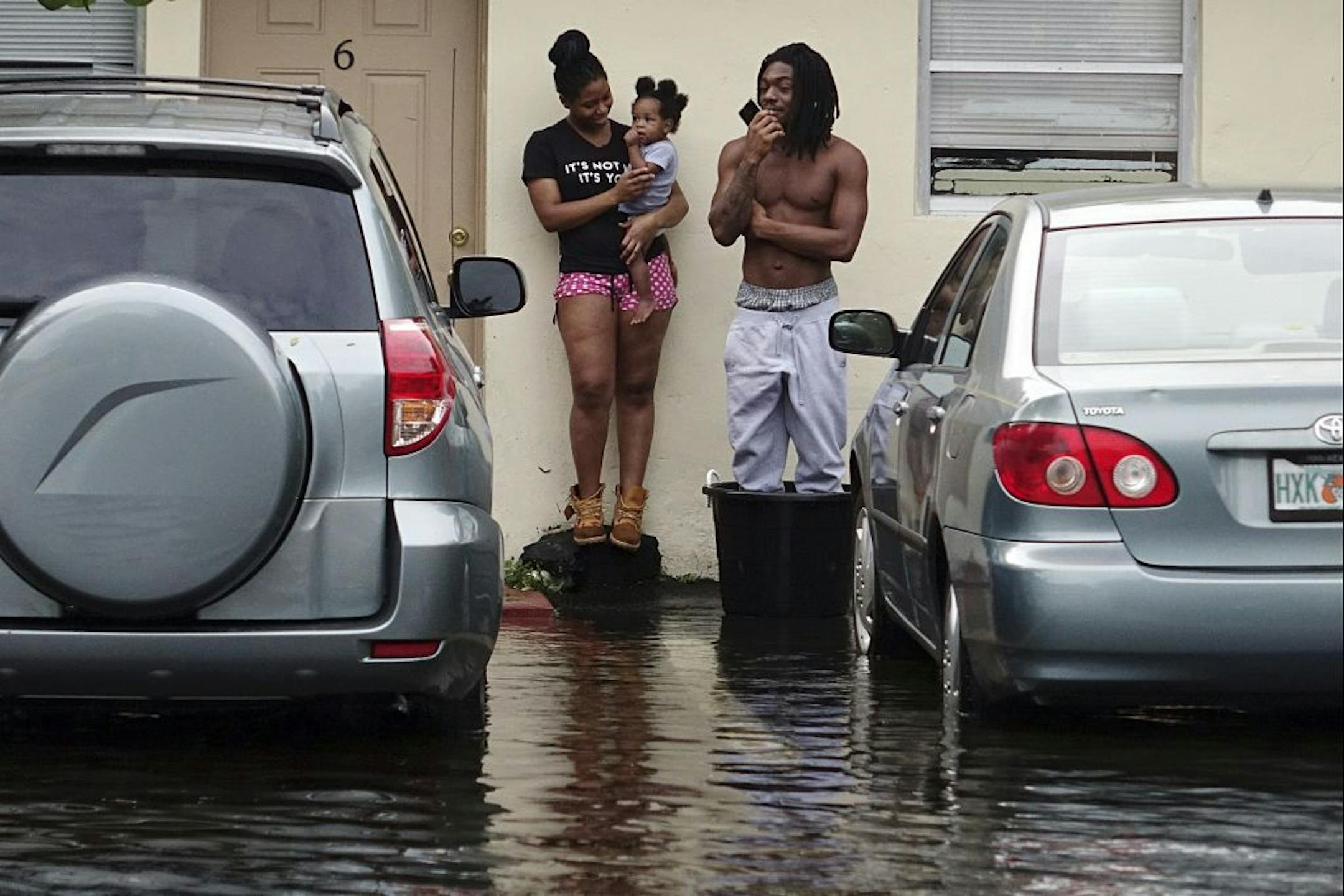 Evan and Denise Knight try to keep dry along with their baby Zion, on a flooded street in Melrose Park in Fort Lauderdale, Fla., Monday, Nov. 9, 2020. Heavy rain from Tropical Storm Eta caused dangerous flooding Monday across Florida's most densely populated urban areas, stranding cars and swamping entire neighborhoods with fast-rising water that had no place to drain.