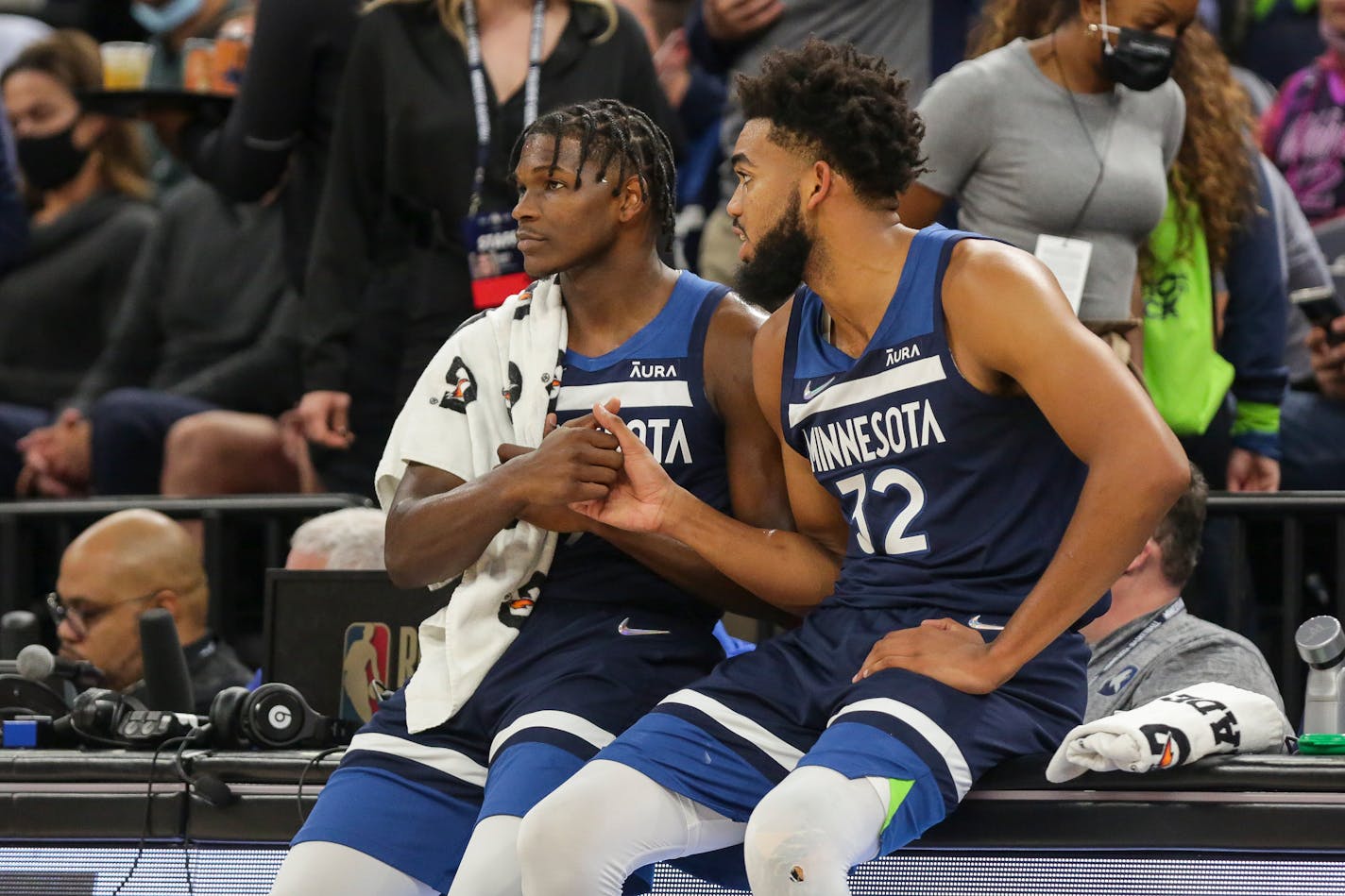 Minnesota Timberwolves center Karl-Anthony Towns (32) and Timberwolves forward Anthony Edwards (1) shake during an NBA basketball game against the Houston Rockets, Wednesday, Oct. 20, 2021, in Minneapolis. (AP Photo/Andy Clayton-King)