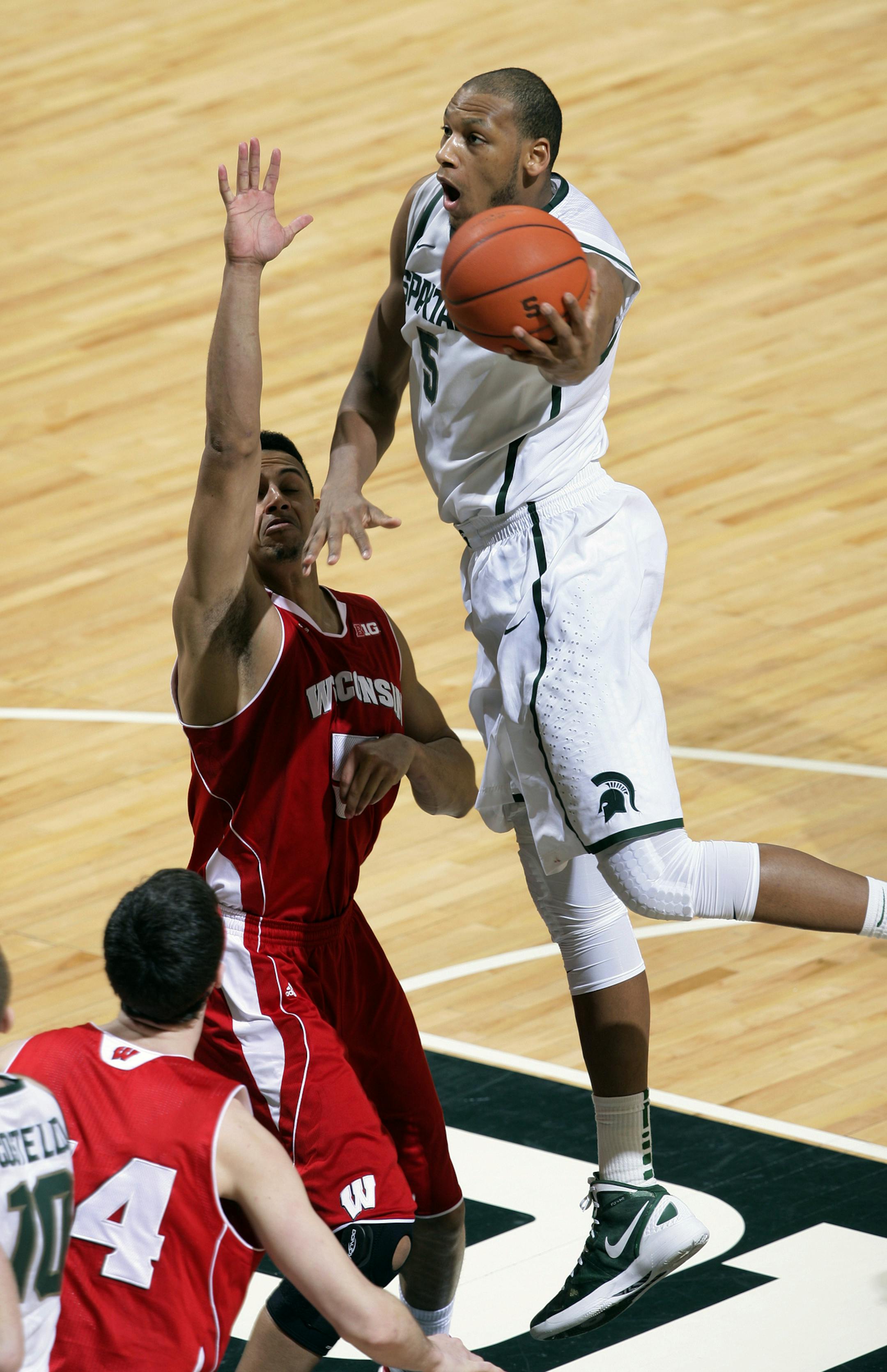 Michigan State's Adreian Payne, right, drives for a shot against Wisconsin's Ryan Evans during the second half of an NCAA college basketball game, Thursday, March 7, 2013, in East Lansing, Mich. Michigan State won 58-43. (AP Photo/Al Goldis) ORG XMIT: MIN2013030722572600