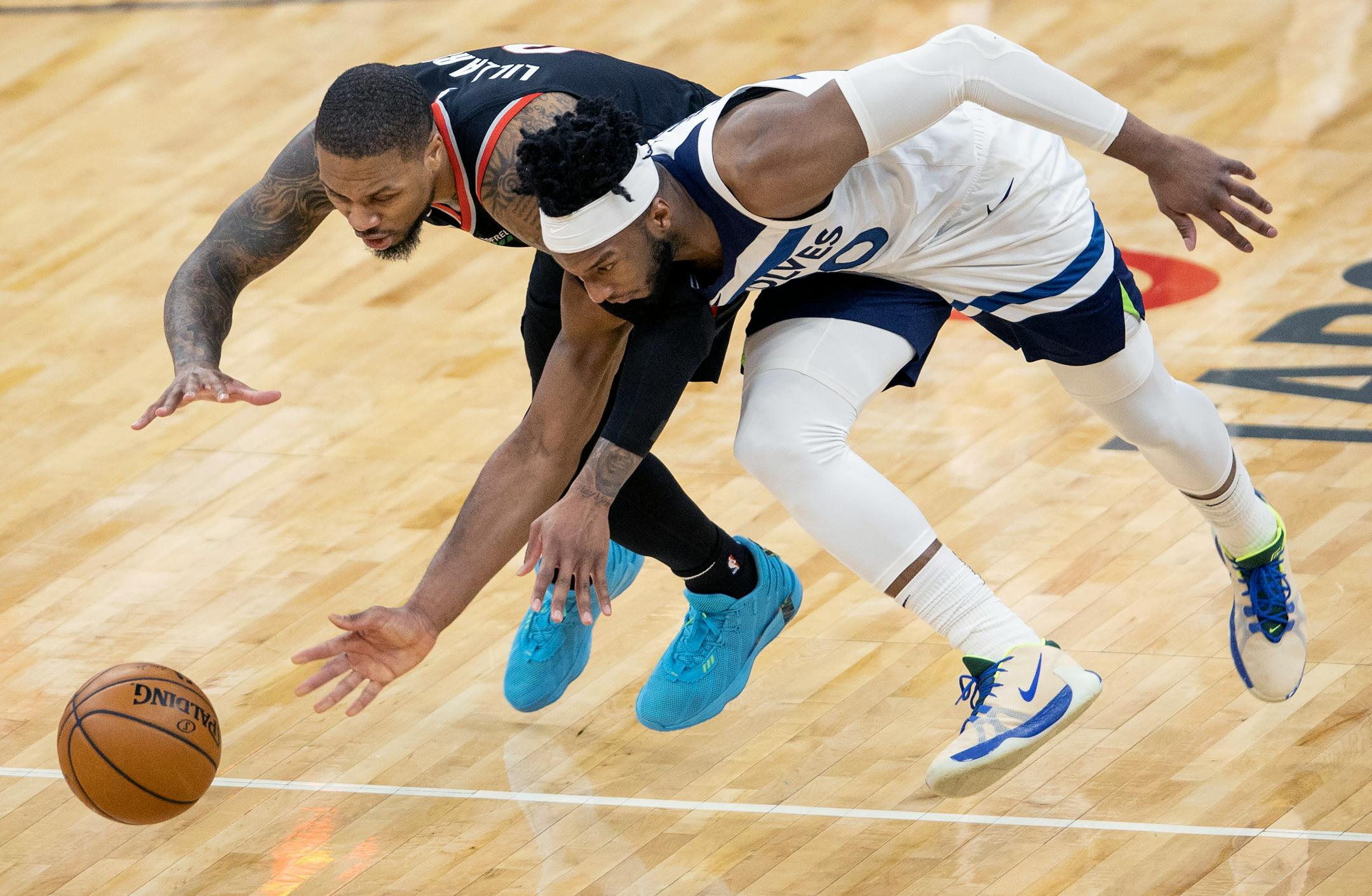 Damian Lillard (0) of the Portland Trailblazers and Josh Okogie (20) of the Minnesota Timberwolves fought for the ball in the fourth quarter.